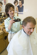 Charlette Lushin is giving Chancellor Steve Jones a haircut.
