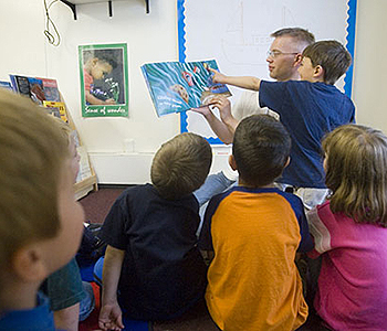 Early childhood education practicum student Karl Eklund reads a book on sea life to a group of youngsters. UAF photo by John Wagner.