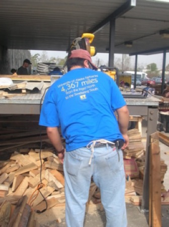 Temple Dillard operates a power saw at the Habitat warehouse. Photo by Clarissa Ribbens.