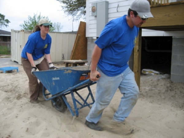 JJ Boggs and Temple Dillard work together to get the wheelbarrow where they need it. Photo by Kari Pile