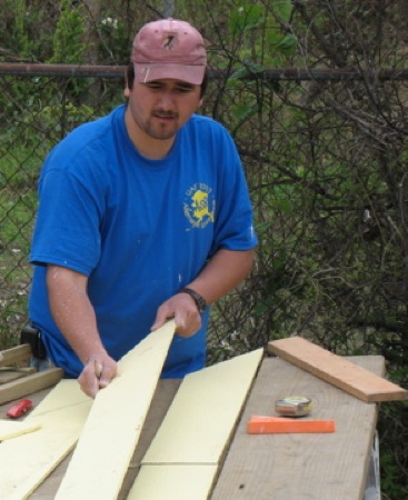 Temple Dillard cuts up pieces of siding for the peak of a Habitat house. Photo by Brian Lyke