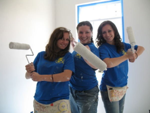 Emily Schooley, Tabitha Johnson and Erica Schooley have a little fun while painting the interior of a Habitat for Humanity house. Photo by Brian Lyke