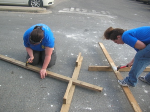 Kari Pile and Tabitha Johnson remove nails from recycled boards. Photo by Clarissa Ribbens