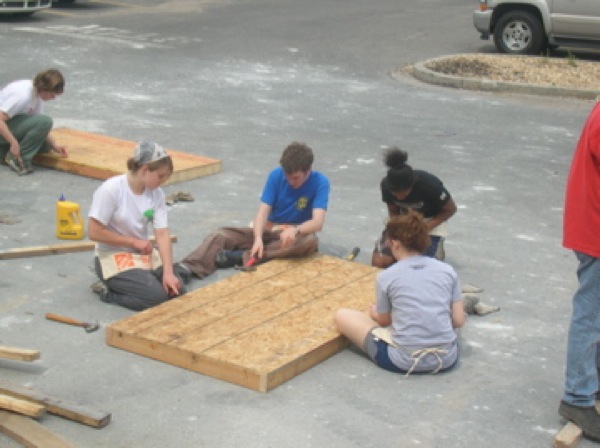 Brian Lyke and volunteers from another college work on building bunk beds. Photo by Clarissa Ribbens