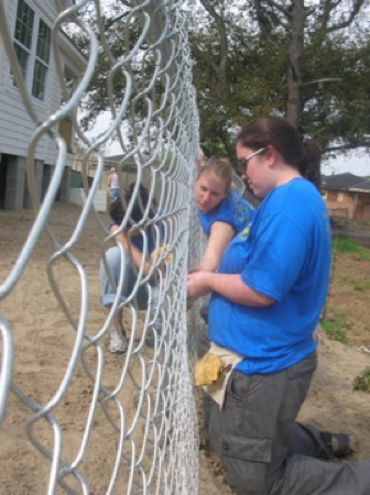 Alexis Fernandez, Cynthia Lashinski and Kari Pile install a fence. Photo by Clarissa Ribbens