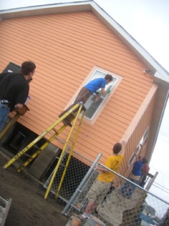 Brian Lyke and Tabitha Johnson touch up the trim paint on a Habitat house. Photo by Clarissa Ribbens