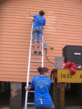 Emily and Erica Schooley apply some touch%2Dup paint on one of the Habitat houses. Photo by Clarissa Ribbens