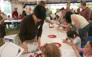 Photo by Kerynn Fisher/UA Museum of the North. Volunteers help children with their Aleut visors at the museum’s 2009 TOTE Family Fun Fest.