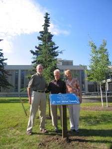 Photo courtesy Nancy TarnaiDavid Klein, Teri Viereck, and Ritchie Musick stand in front of a white spruce planted in memory of Leslie Viereck.