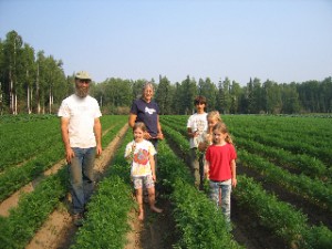 Photo by Nancy Tarnai..  Pete and Lynn Mayo in their carrot patch with their children and niece.
