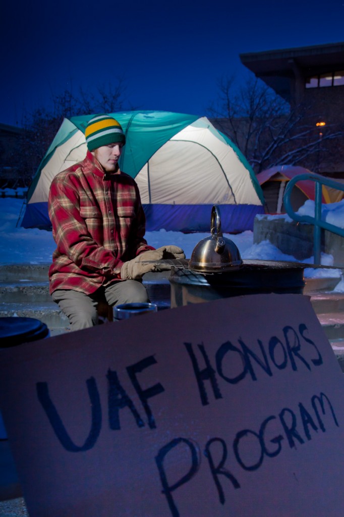 Photo by Todd Paris.. Freshman John Scott warms himself by a barrel stove during a week-long vigil by students in the UAF Honors Program to bring awareness to the issue of homelessness.