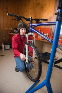 Sophomore engineering major Michael Stanfill tightens the front wheel on a brand new mountain bike - one of 20 being assembled and loaned to students as part of a new sustainability effort on campus.