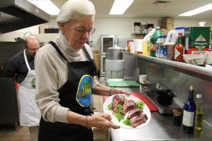 Photo by Nancy Tarnai. Carol Lewis displays the reindeer loin she cooked upstairs in the Wood Center kitchen. The meat, high in protein and low in fat, is raised at the Fairbanks Experiment Farm.