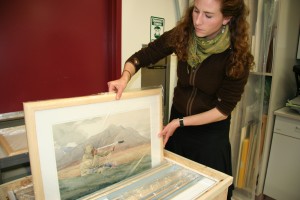 UA Museum of the North photo. University of Alaska Museum of the North fine arts curator Mareca Guthrie packs up reproductions of watercolors by artist Jeffries Wyman for the Simon Paneak Memorial Museum in Anaktuvuk Pass. 