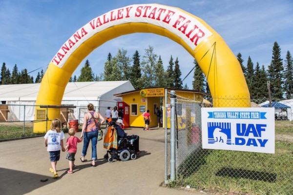 A group of people enter the Tanana Valley State Fair during UAF Day.