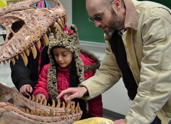 Photo by Meghan Murphy.  Matt Seymour and his daughter examine teeth of a dinosaur skull mold at the 2013 Science Potpourri.