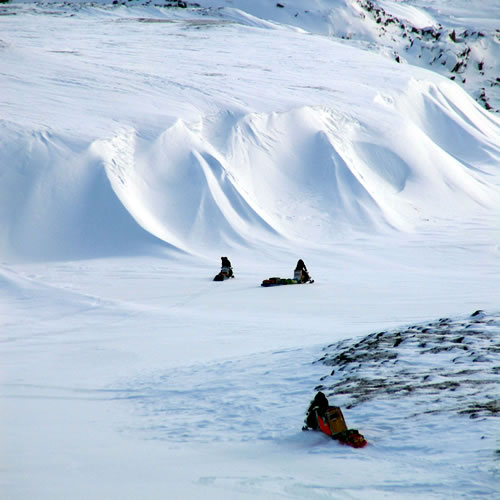 Photo by Matthew Sturm. Matthew Sturm’s partners on a 2007 snowmachine traverse head toward Daring Lake in Canada’s Northwest Territories.