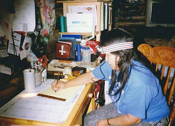 Photo courtesy of Caroline Tritt-Frank. Caroline Tritt-Frank wears a headlamp while doing homework for her correspondence courses in the late 1980s. Her family's Arctic Village cabin didn't have electricity at the time.