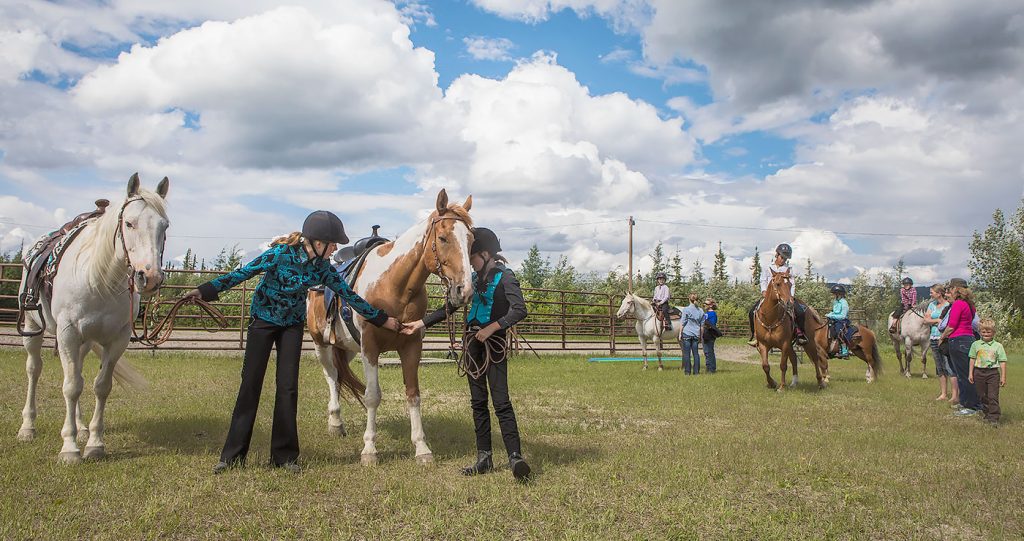 UAF photo by JR Ancheta. Ainsley Smith, left, and her sister McKenna work with horses during a 4-H Club event organized by the Cooperative Extension Service at the Tanana Valley State Fair's grounds. A variety of events, including 4-H displays, will be held at UAF Day at the fair on Aug. 7.