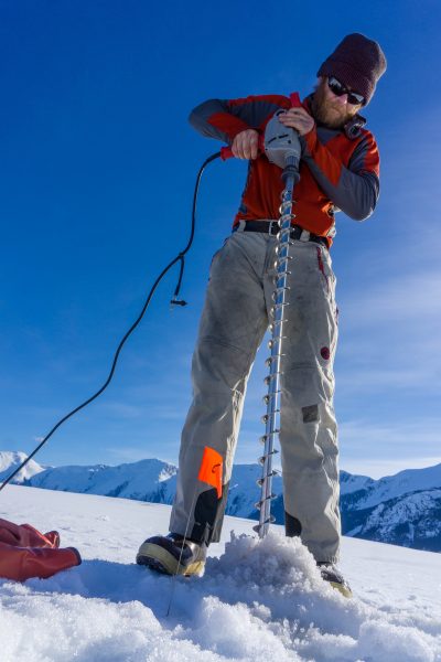 Photo courtesy of Douglas Brinkerhoff . Martin Truffer drills holes for explosives in the surface of Taku Glacier. The explosions produce seismic waves that bounce off the sediment below the glacier, providing information about its thickness and character.