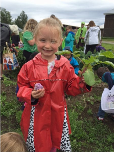 Photo by Stephen Brown. A participant at last year's Agriculture Appreciation Day at the Farm shows off a radish she harvested.