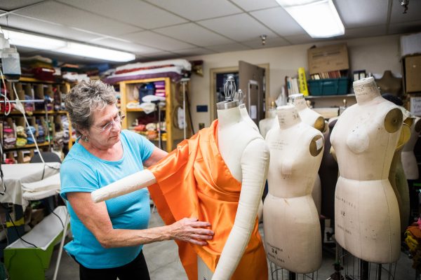 UAF photo by JR Ancheta. Costume Shop manager Jerene Mosier drapes fabric over a mannequin in her office. She makes many of the items that are used in UAF theater and film productions.
