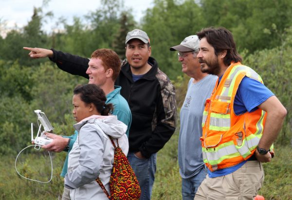 Photo by Yuri Bult-Ito. After a demonstration by Matt Macander of ABR Inc., right, participants in the science and culture camp try flying a drone over the hills in Unalakleet.