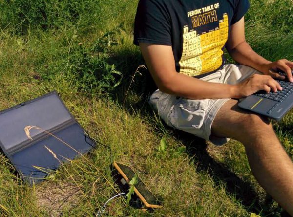 Photo by Vanessa Raymond.  Ianjon Brower tests a solar-powered prototype of a computer that can monitor ice cellars while sitting outside of the University of Alaska Fairbanks’ Geophysical Institute.