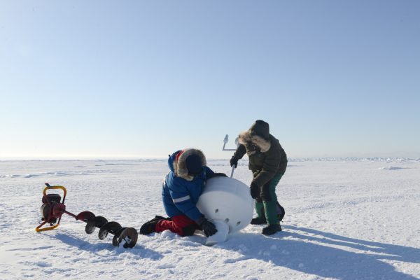 Photo by Ignatius Rigor of the Polar Science Center, Applied Physics Laboratory University of Washington. . A research team deploys an ice beacon on sea ice north of Utqiagvik (formerly known as Barrow), Alaska's northernmost community.