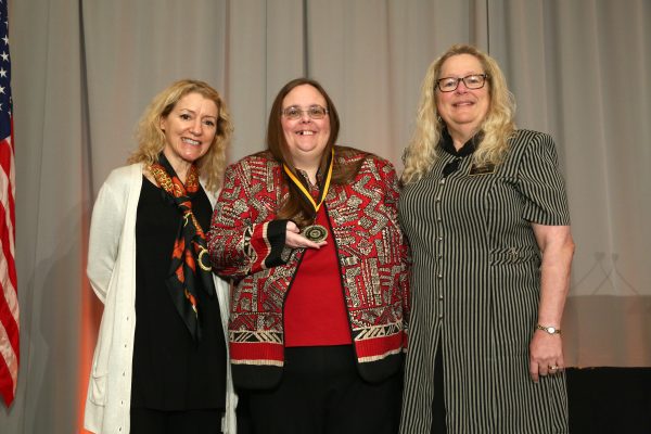 Photo courtesy of American Mathematical Association of Two-Year Colleges.  UAF Assistant Professor Lorinda Fattic, center, accepts her award during the American Mathematical Association of Two-Year Colleges' conference in November. AMATYC President Jane Tanner, right, presented Fattic with a medallion. Chris Hoag, left, with the textbook publisher Pearson, gave Fattic a $500 check.