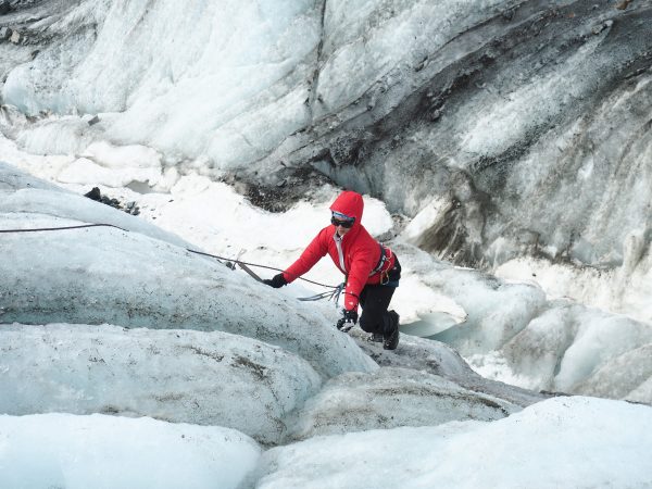 Photo by Alexandra Ravelo.  A participant in Girls on Ice Alaska learns how to ice climb out of a crevasse on a glacier.