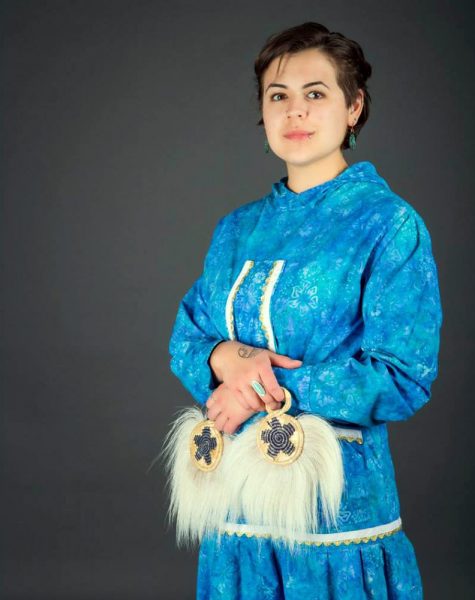 Photo by Bax Bond.  Caitlin Tozier models a kuspuk and dance fans similar to those used in performances during the annual Festival of Native Arts at the University of Alaska Fairbanks. Tozier works as the festival's student coordinator.