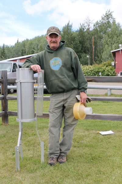 Photo by Debbie Carter. Fairbanks Experiment Farm manager Alan Tonne stands by the rain gauge. He checks the weather daily.