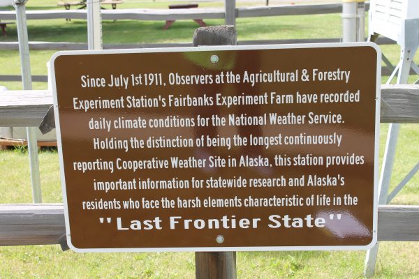 Photo by Debbie Carter. A National Weather Service sign at the Fairbanks Experiment Farm recognizes the weather station's history.