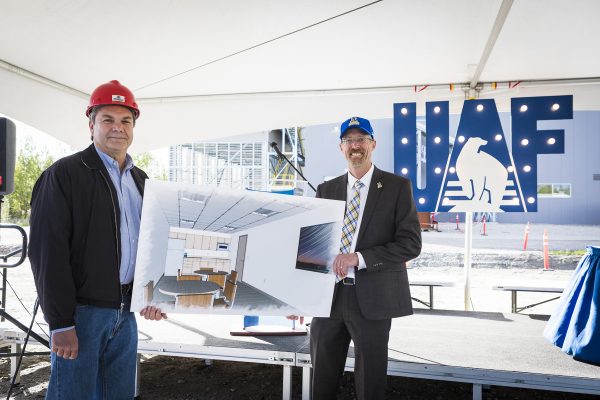 UAF photo by JR Ancheta. Usibelli Coal Mine President and CEO Joe Usibell Jr. and University of Alaska Fairbanks Chancellor Dan White stand with rendering of the new training classroom at the UAF combined heat and power plant.