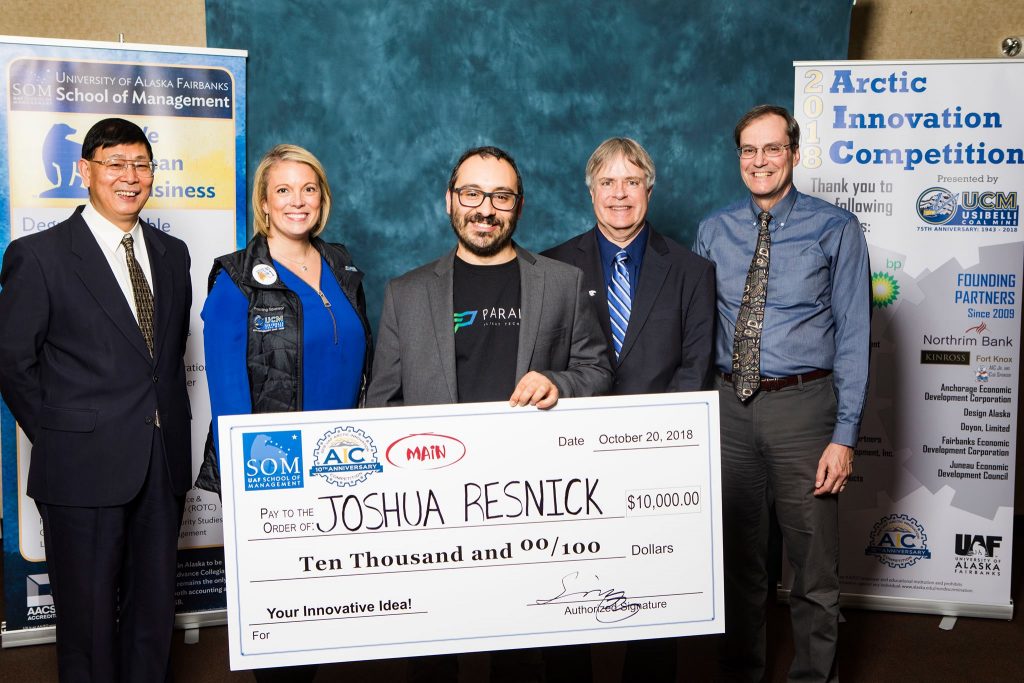 UAF photo by JR Ancheta. Joshua Resnick holds his winning check at the 2018 UAF Arctic Innovation Competition.