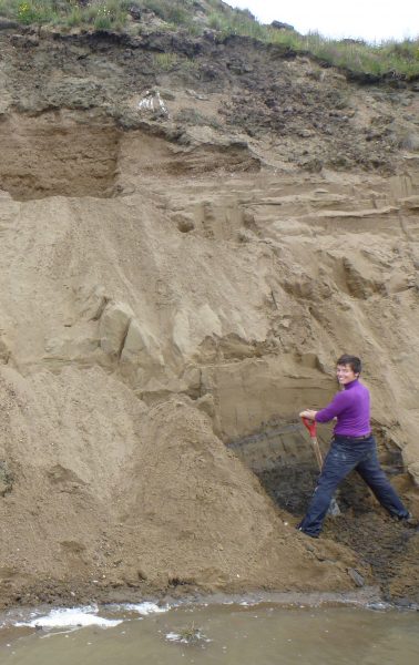 Photo by Guido Grosse. Louise Farquharson, a postdoctoral researcher at UAF’s Geophysical Institute, digs into an ancient beach on the north shore of Teshekpuk Lake.