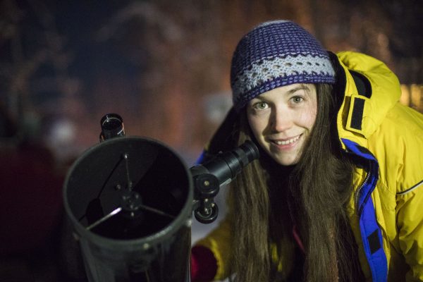 UAF photo by JR Ancheta. University of Alaska Fairbanks graduate student Geneva Mottet stands by her personal telescope during the 2017 Astropalooza.
