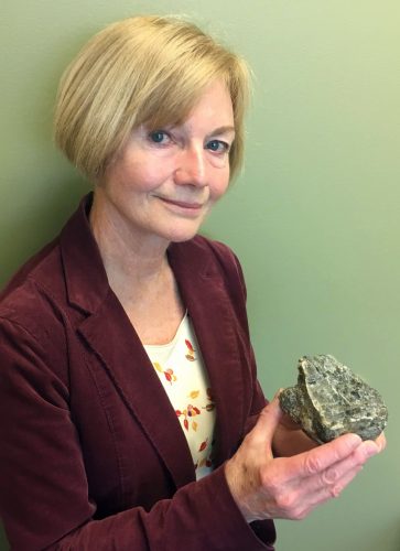 Photo by Adrian Bender. Geologist Marti Miller with a 2-billion-year-old rock she collected near Iditarod.