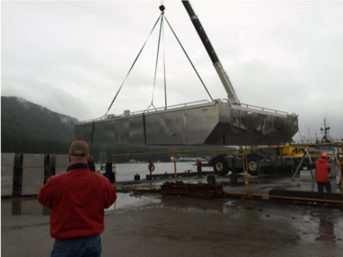 Blue Starr Oyster Co.'s FLUPSY is carried by a crane before being lowered into the water in Ketchikan. Photo courtesy of Gary Freitag.
