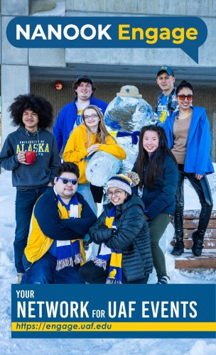 Eight students dressed in blue and gold winter gear and of different genders and ethnicities cluster around an ice sculpture of a polar bear outside the Gruening Building.
