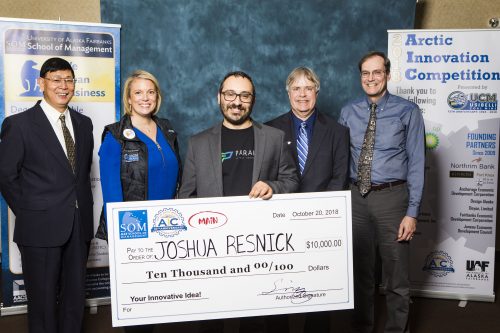 UAF Photo by JR Ancheta. Joshua Resnick holds his winning check for his Parallel Drones idea from the 2018 UAF Arctic Innovation Competition.
