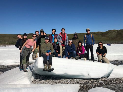 Photo by Jessica Wohlrob. PEP AK and REU students pose on river ice, known as aufeis, during their visit to the Arctic this summer.