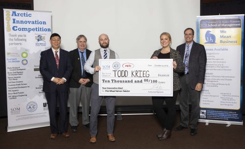 UAF photo by JR Ancheta. Todd Krieg holds his winning check for his Fish Wheel Salmon Selector idea from the 2019 UAF Arctic Innovation Competition.