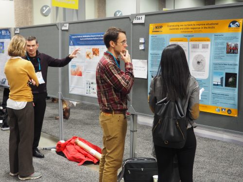 People looking at scientific posters in an exhibit hall.
