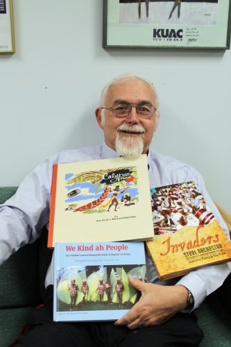 Photo by Nancy Tarnai. Ray Funk displays books he has written about music and culture. Funk is celebrating 40 years as a KUAC volunteer.