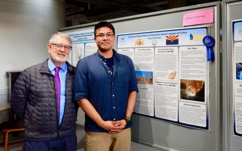 Anthropology senior Kendrick McCabe, right, won a 2019 Dean's Choice Award for his poster on reclaiming traditional names to promote Diné (Navajo) language and culture. Standing next to him is Todd Sherman, dean of the College of Liberal Arts. McCabe's presentation was part of the 2019 Research and Creative Activity Day. Photo courtesy of the Undergraduate Research and Scholarly Activity program.