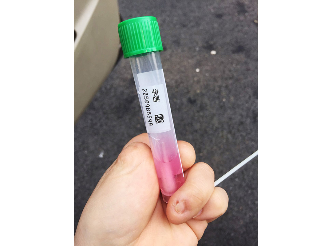 Qian Li holds a sample in a vial. Her production team was tested for COVID-19 periodically while covering the pandemic in Wuhan. Photo by Qian Li.