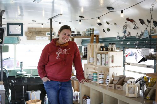 Photo by Elizabeth Talbot. UAF alumna Erica Moeller shows some of the wares at The Roaming Root, her bus-based retail outlet for local products.