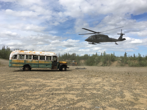 Photo courtesy of Alaska DNR. Bus 142 is shown with a UH 60 Blackhawk helicopter that supported the Alaska Army National Guard operation that transported the bus from the Stampede Trail to an interim staging point on the Stampede Road.